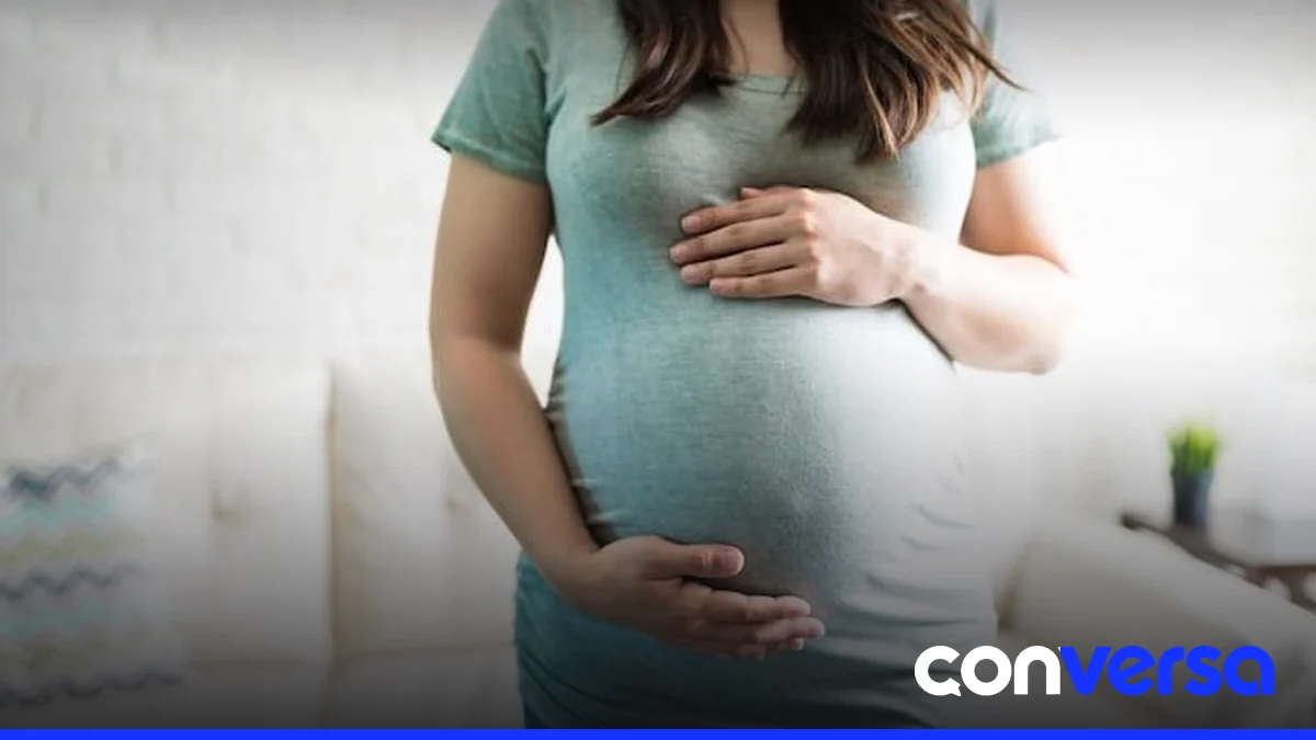 Mujer embarazada en consulta médica, con profesional de salud.