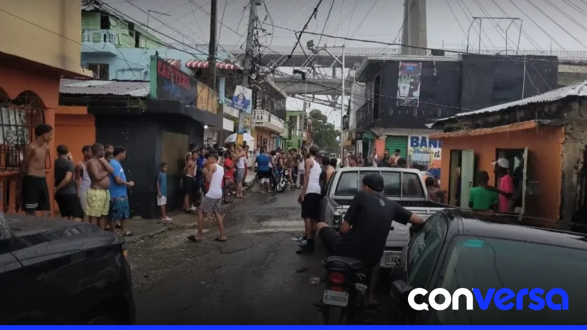 Jóvenes celebran un teteo en las calles de Santo Domingo durante lluvias intensas.